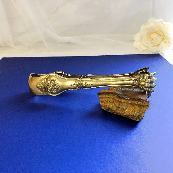 Pince à glaçons ou sucre cuivre doré pattes de lion décor Rocaille